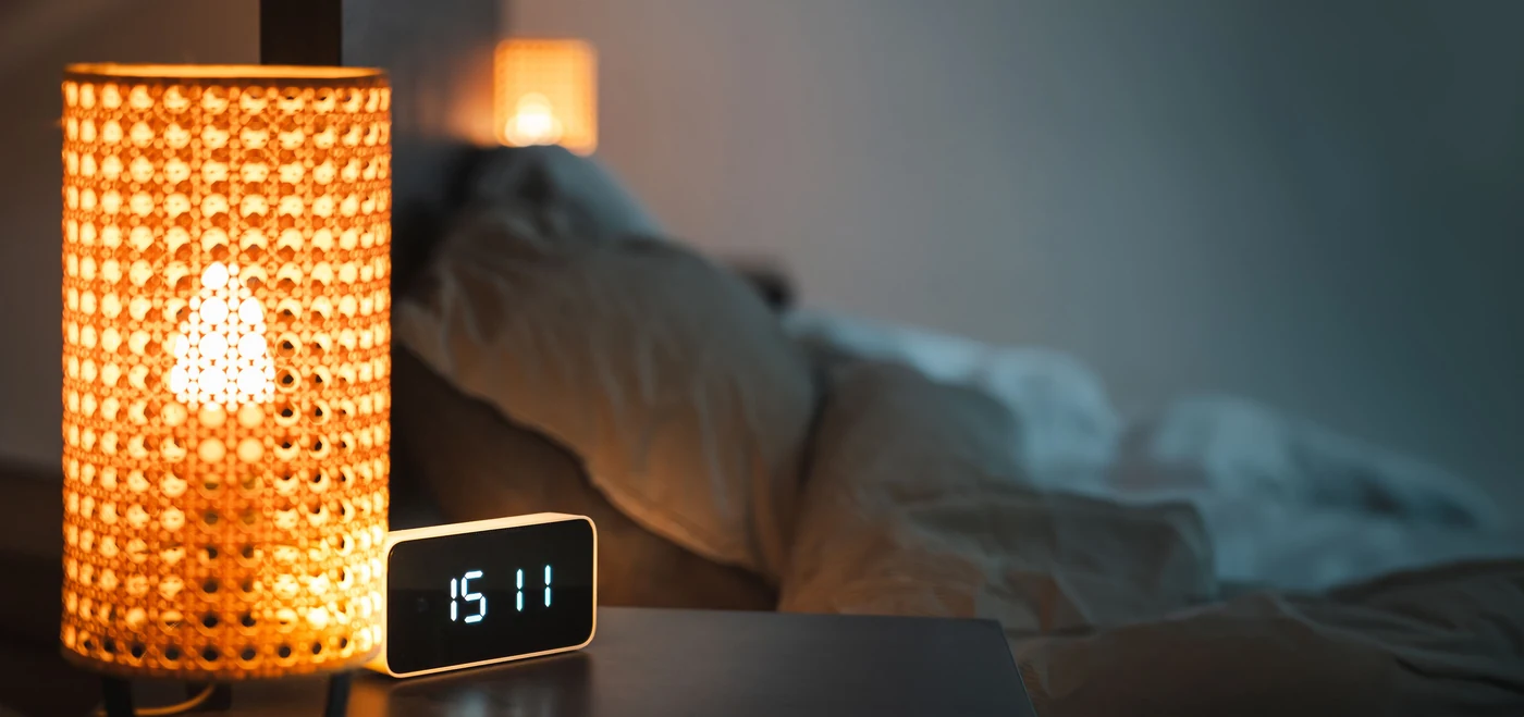 Bedside lamp and digital clock in a bedroom