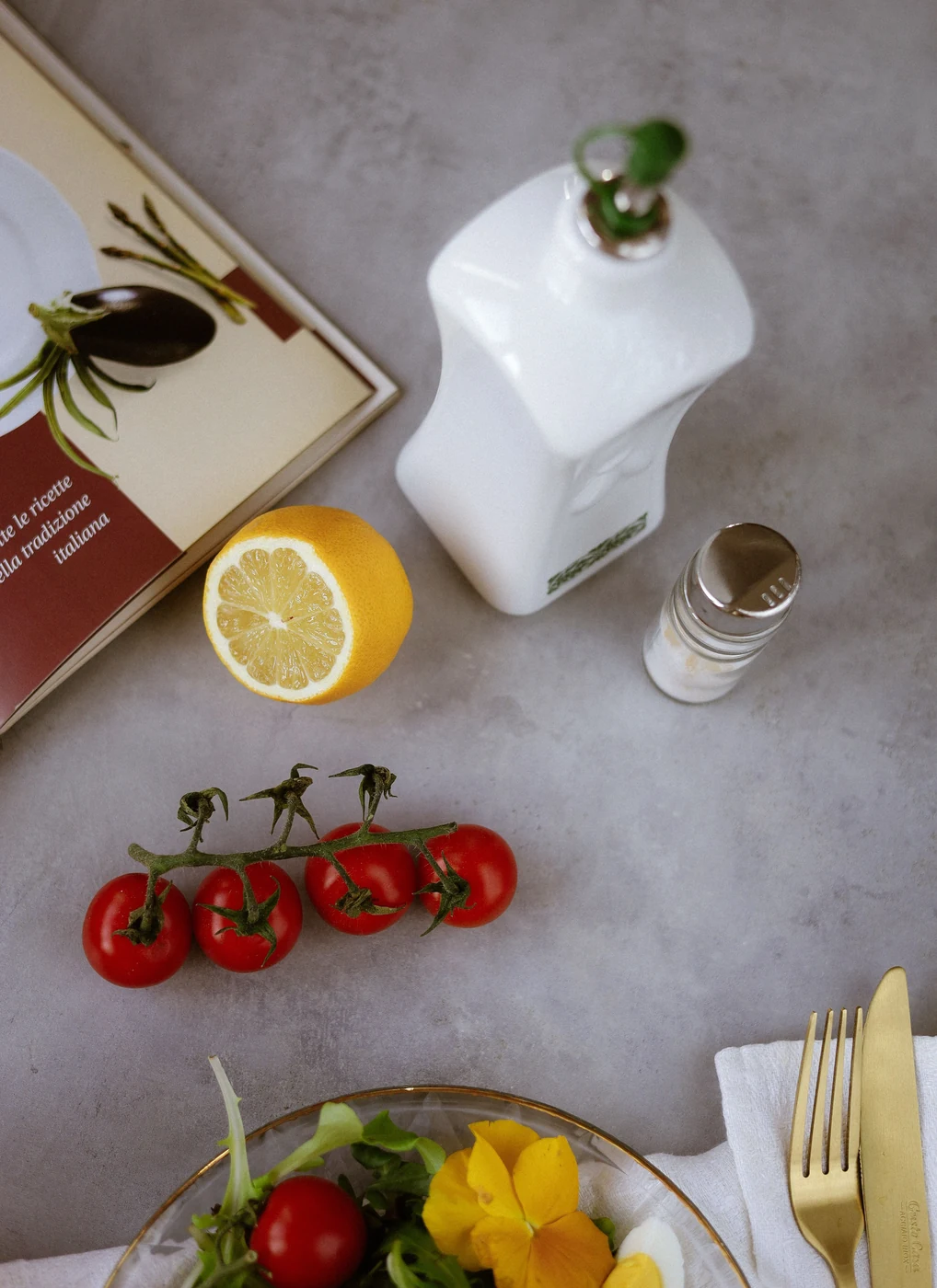 Fresh vegetables, olive oil and kitchen ingredients arranged on a table